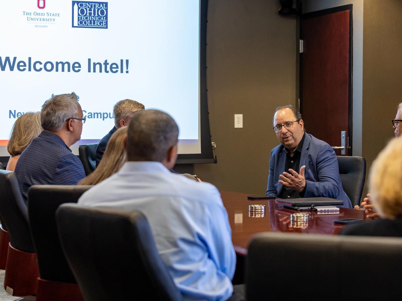 Intel Chief Global Operations Officer Keyvan Esfarjani address a group of people seated at a conference table.