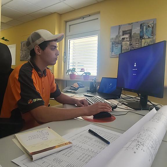A students sits at a computer in a German office while interning in the country.