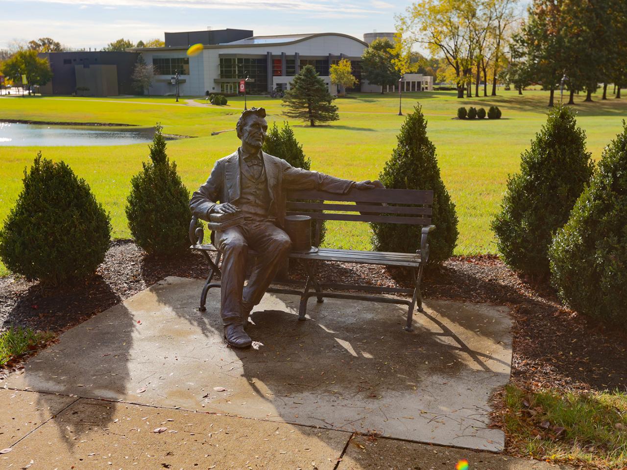 A bronze statue of Abraham Lincoln on a bench. 