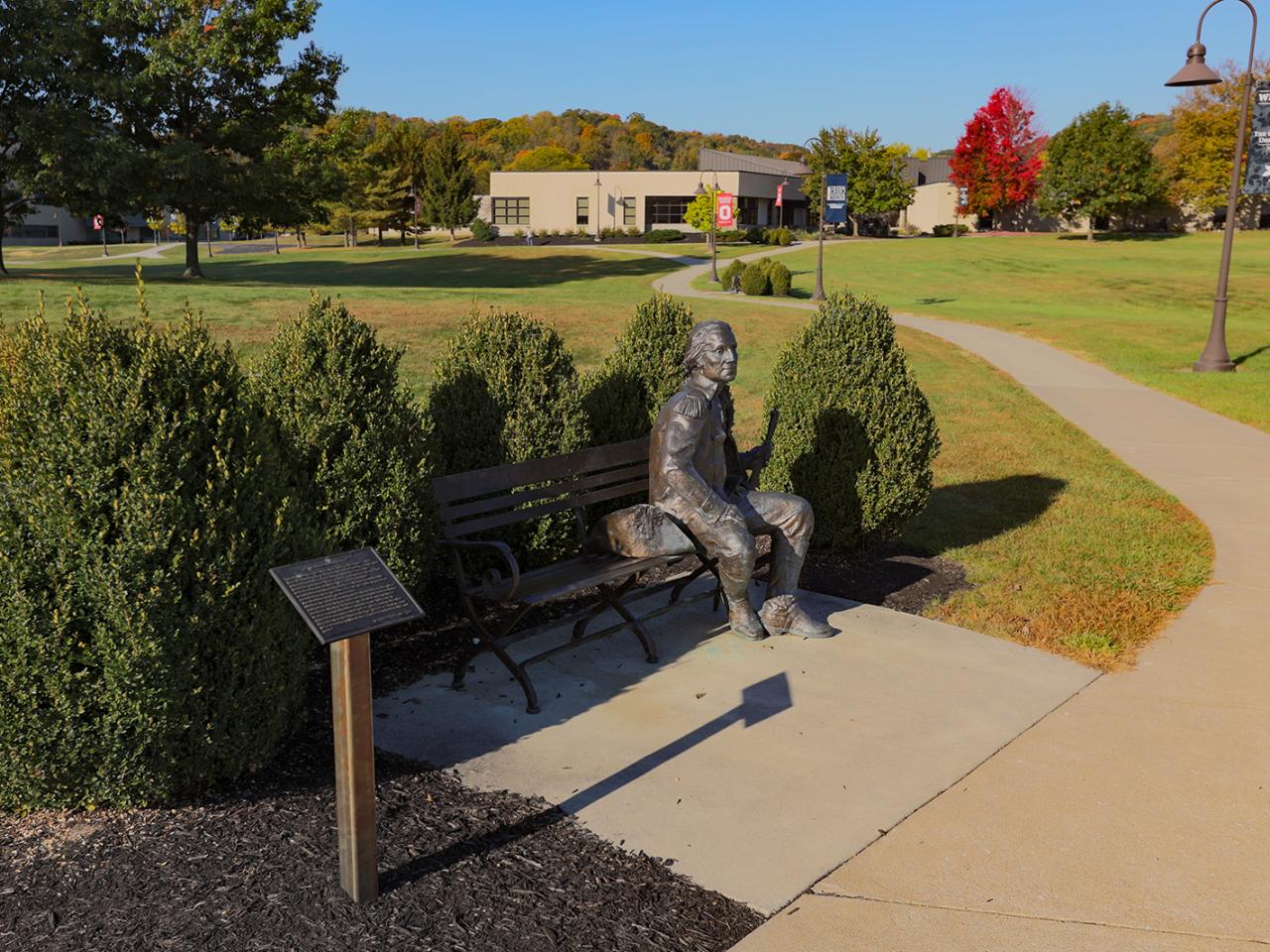 A bronze statue of George Washington seated on a bench.
