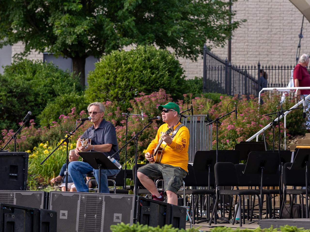 The two-man band Sticks & Stones play guitars and sing under the Martha Grace Reese Amphitheatre.  