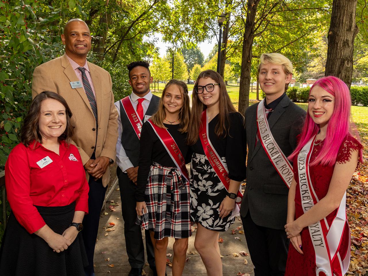 Homecoming court members and Office of Student Life staff members stand together for a photo outside.