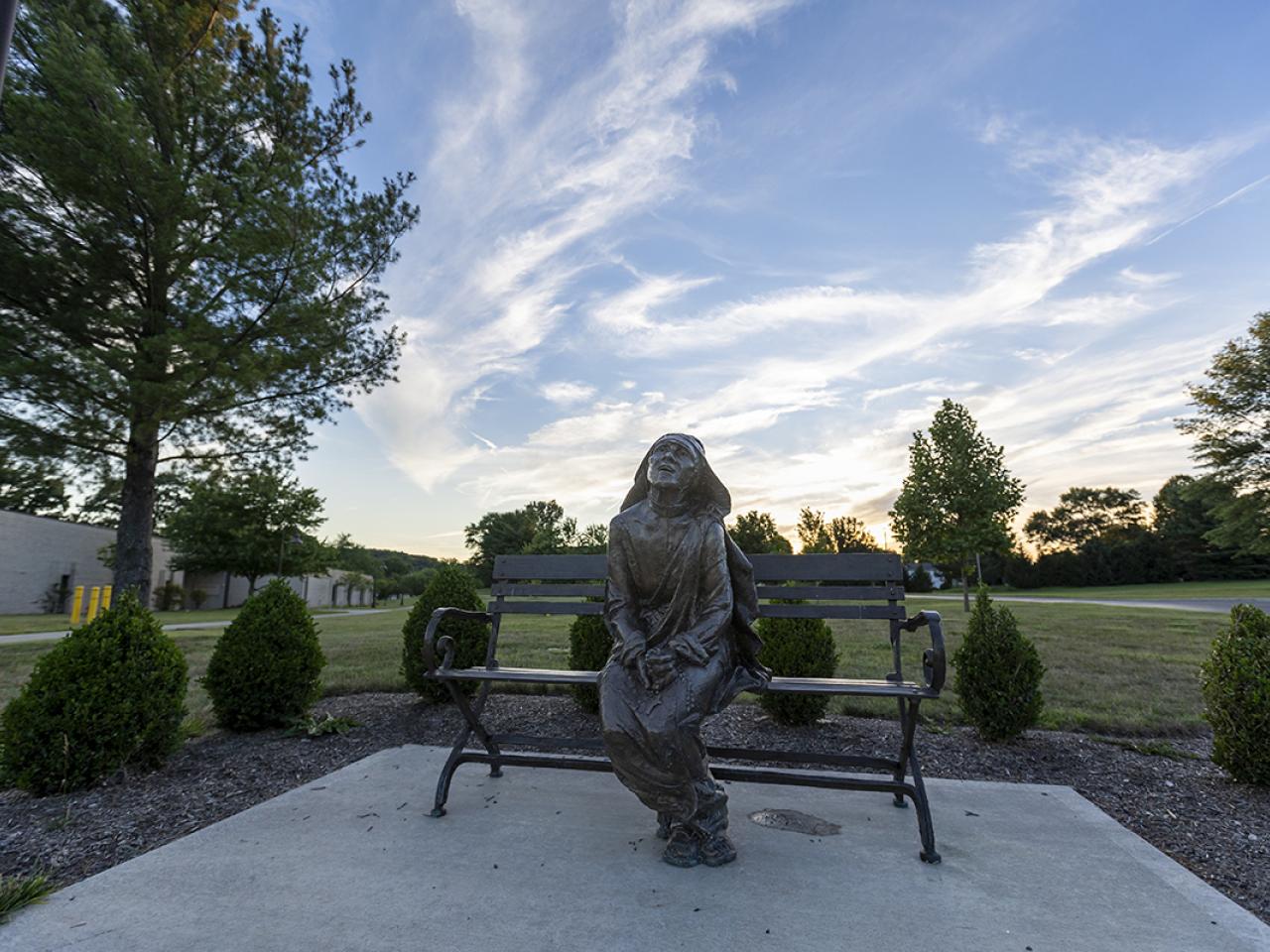 A bronze statue of Mother Theresa on a bench by artist Gary Lee Price on the campus.