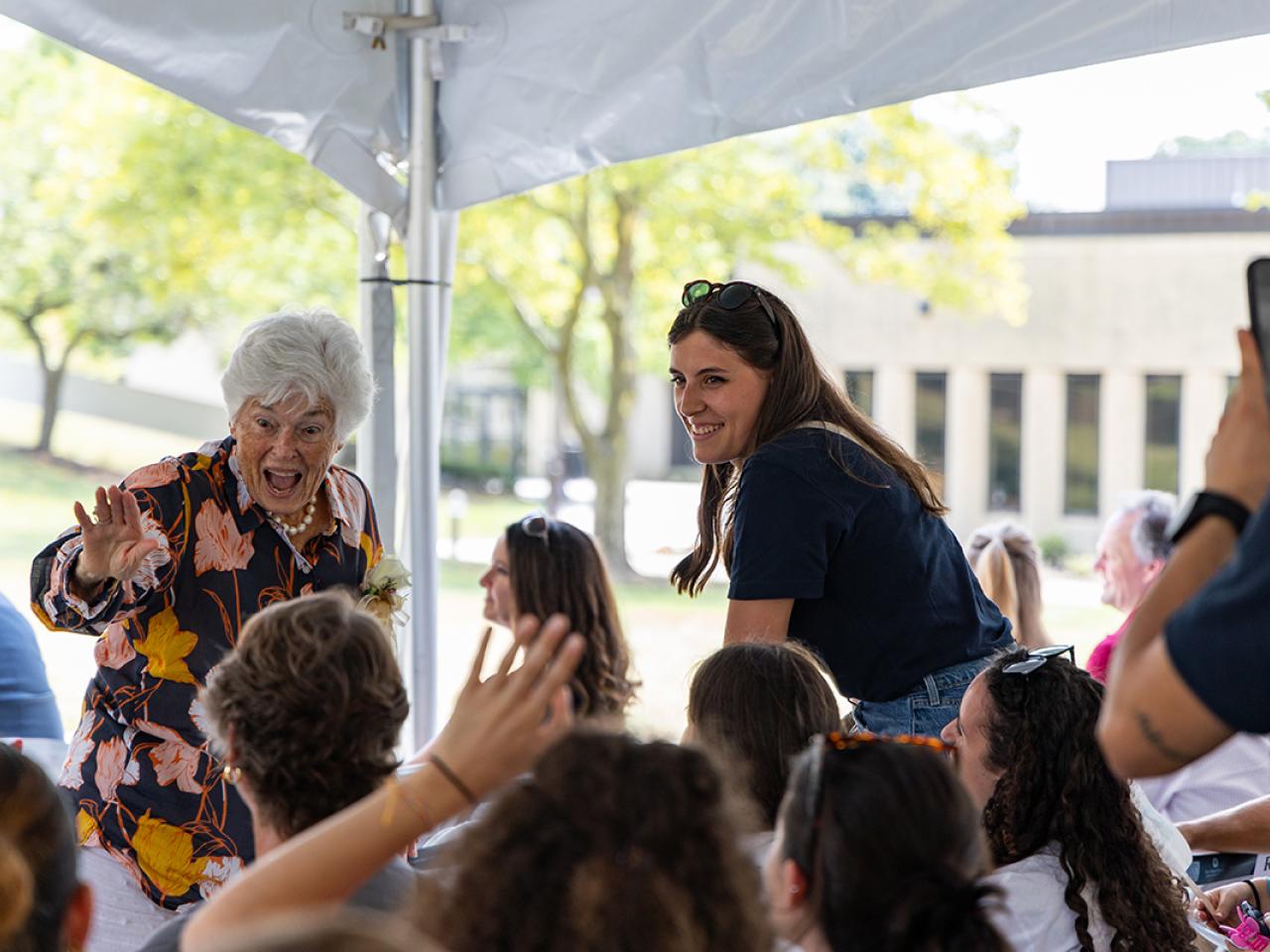 Mrs. Louella Reese waves to people in the audience of a ribbon cutting ceremony for a building named in her honor.