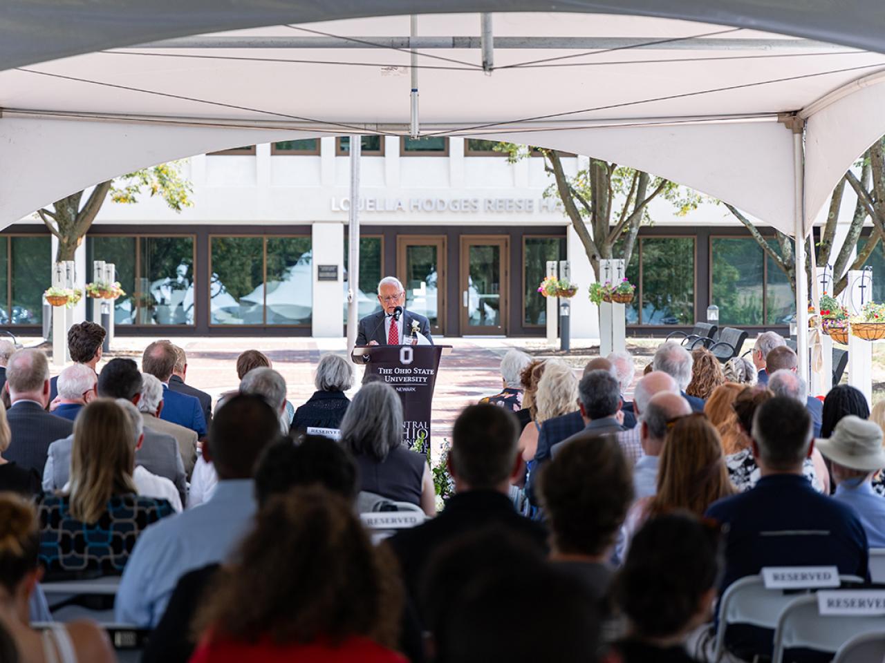 Bob McGuaghy address attendees at a ribbon cutting ceremony for the newly renovated Hodges Hall.