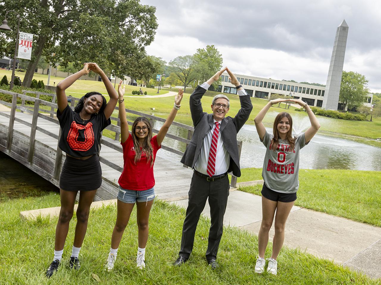 Dean Matt Smith and three students form O-H-I-O with their arms.