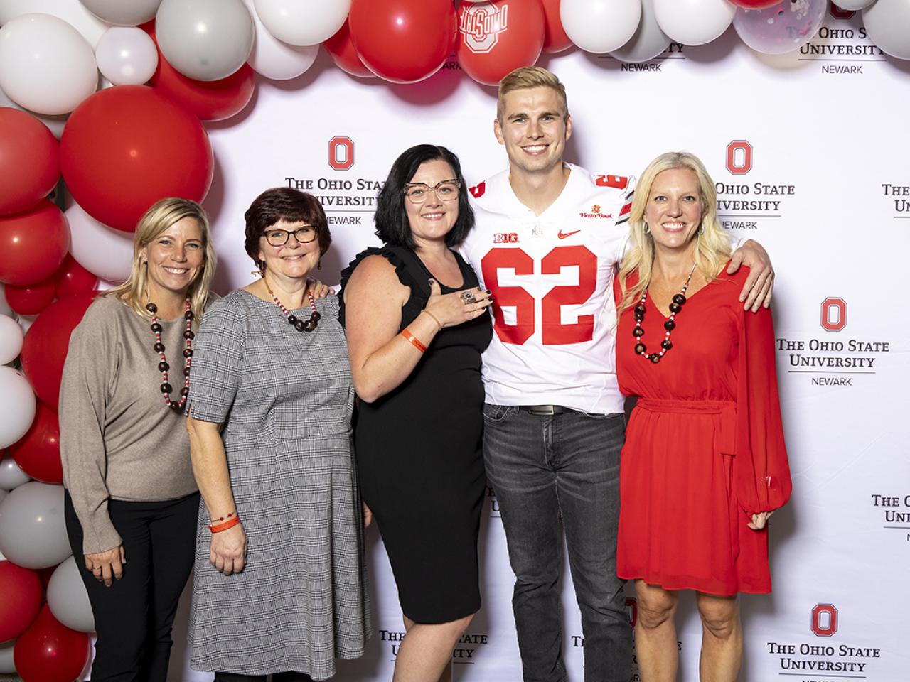 Advancement office staff take a picture with keynote speaker and former Ohio State football player Aaron Parry.