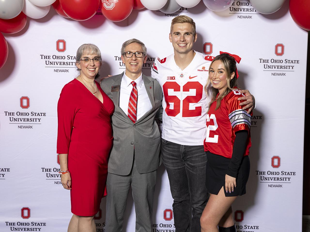 Dean Matthew Smith and family take a picture with keynote speaker and former Ohio State football player Aaron Parry.