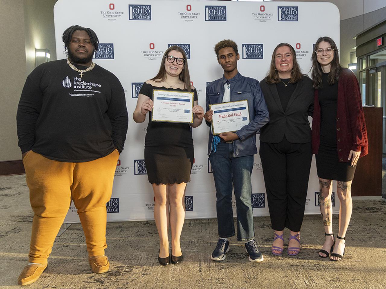 Portrait of students in CAB and Pride Out Loud student organization with their award plaque.