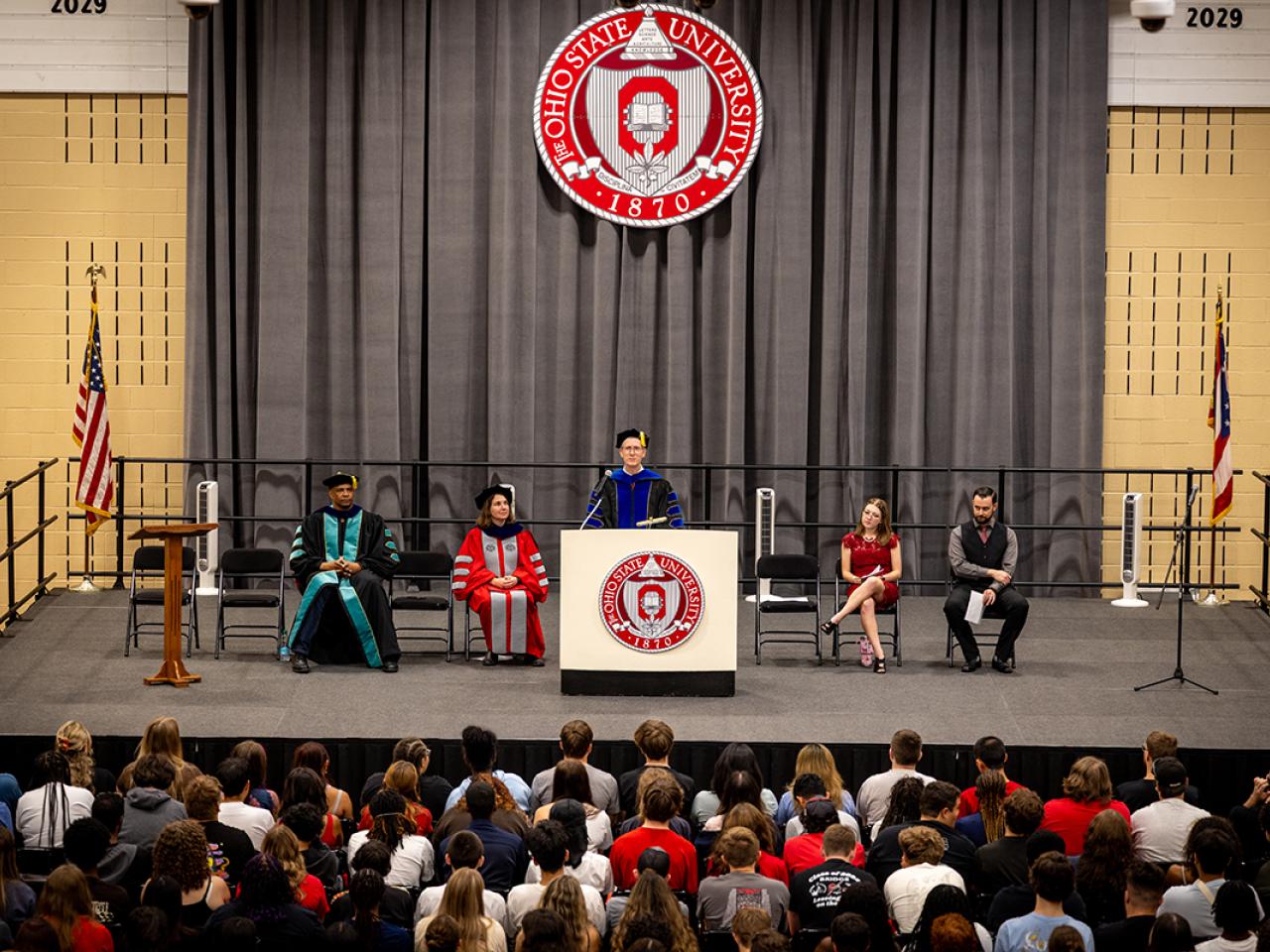 Ohio State Newark Dean and Director Matt Smith speaks from a podium during Convocation.