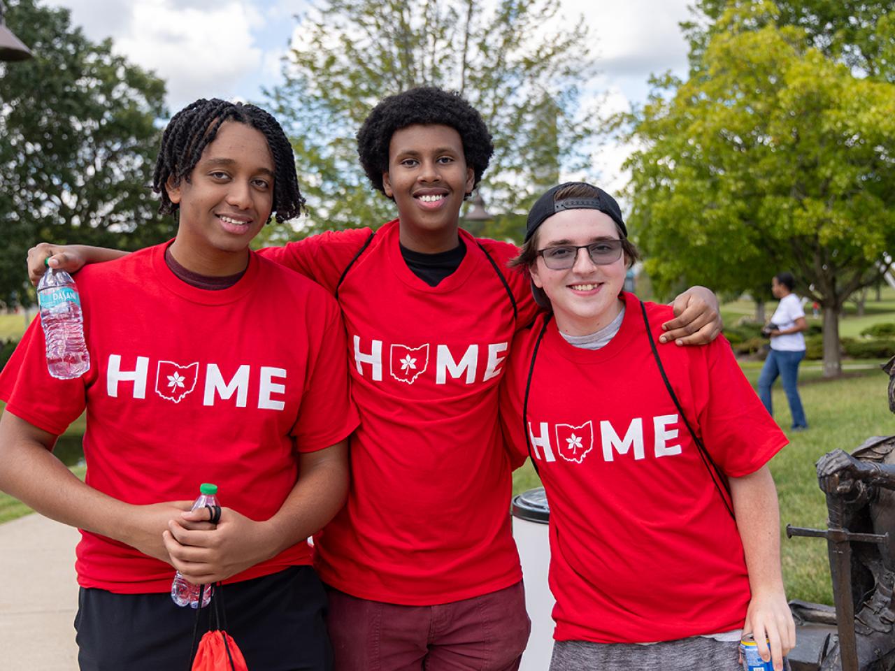Three students pose on campus following Convocation.