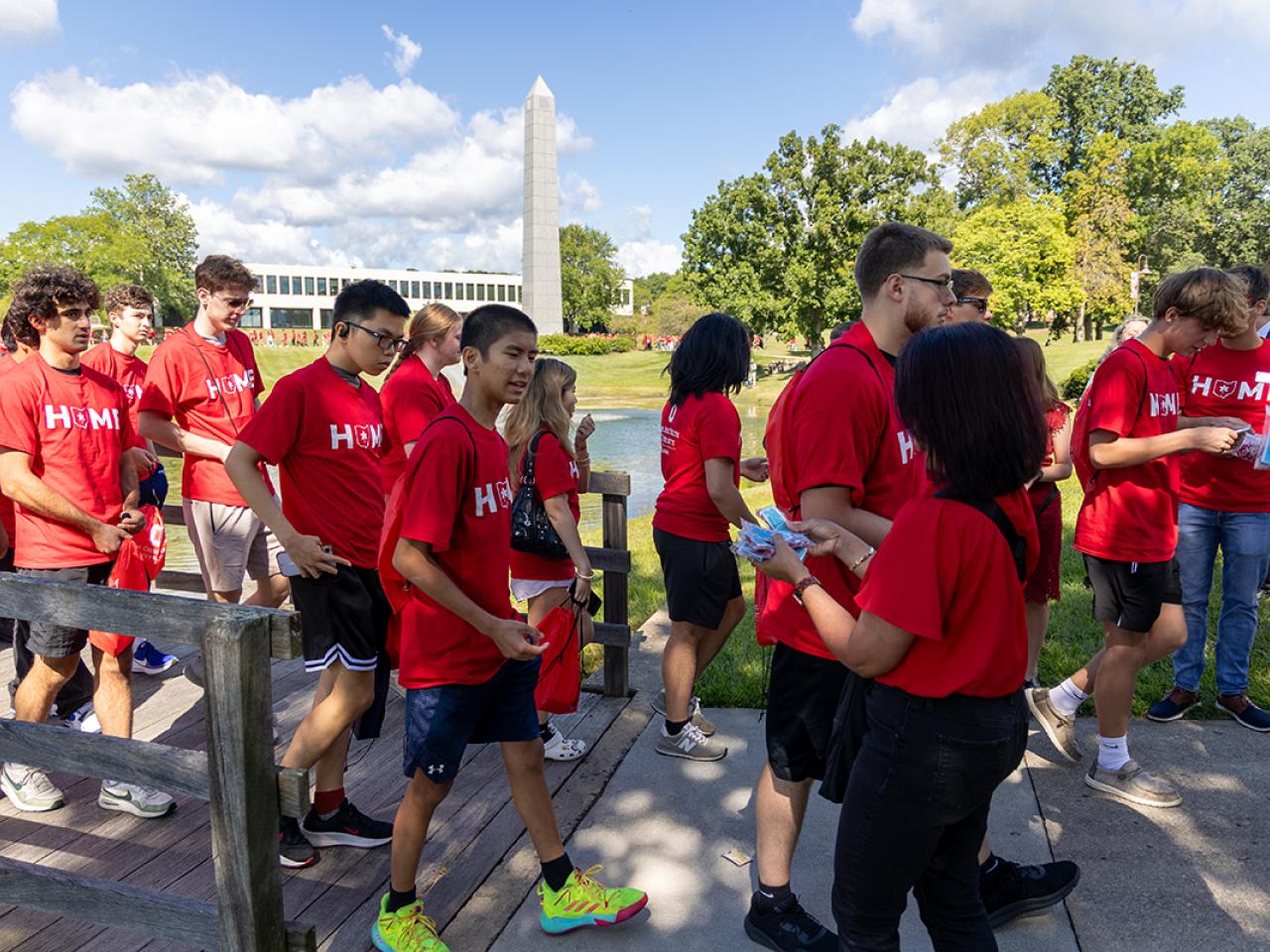 Students walk across the bridge on campus to receive scarlet and gray tassels following Convocation.