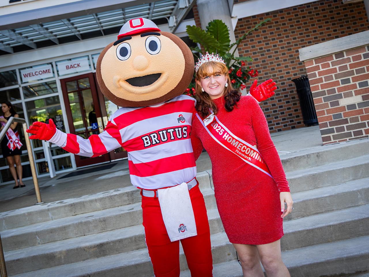 Ohio State Newark Homecoming Court member Acacia Rhodes with Brutus Buckeye outside the Longaberger Alumni House for the regional campus Homecoming recognition ceremony.