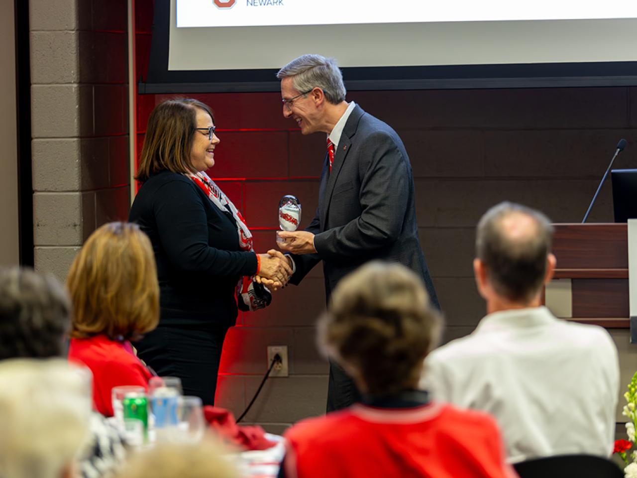 Dean and Director Matt Smith presents the Distinguished Alumni Award to Jodie Wheeler.