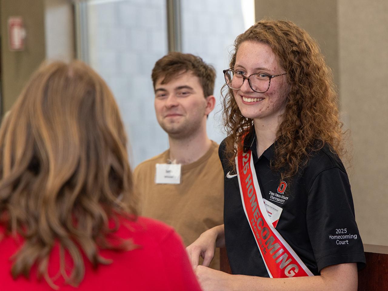 A student on the Homecoming court talks with a guest at the alumni Homecoming dinner.