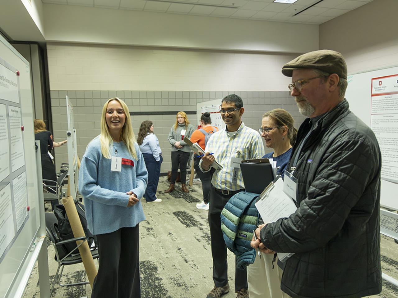 Kinsey Lynch gives her poster presentation to the faculty judges at the Student Research and Creative Inquiry Forum. 