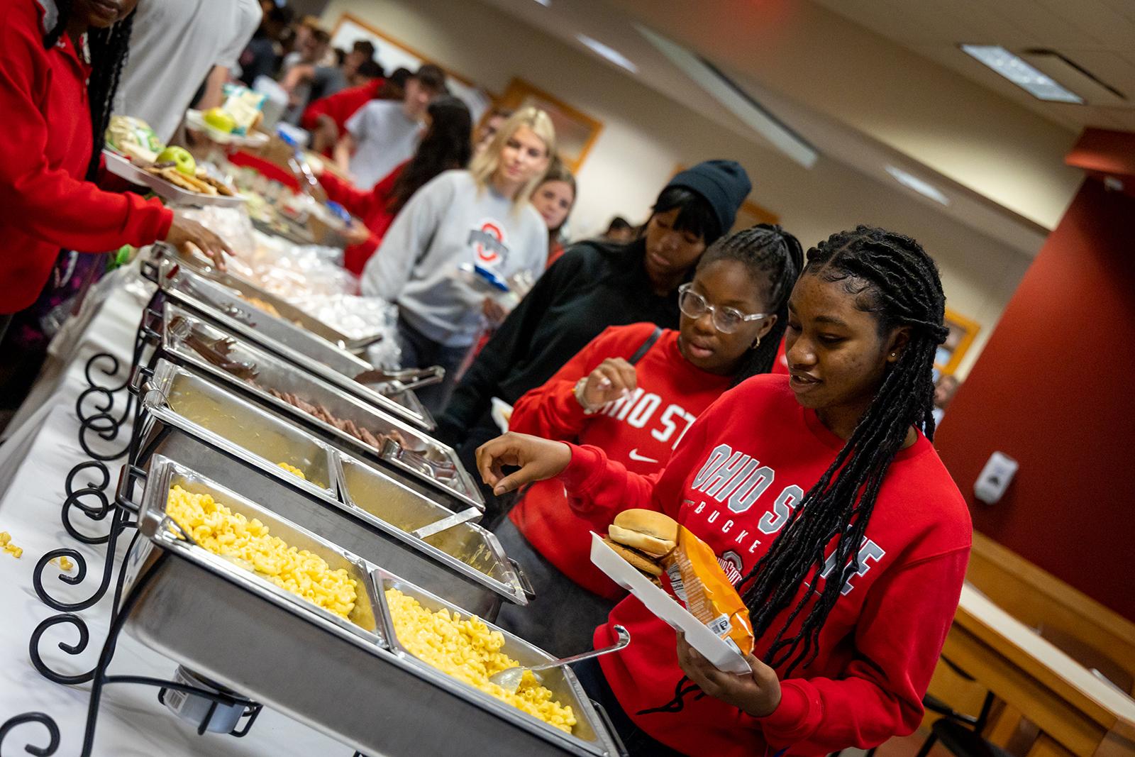 Students serve themselves from chafing dishes.