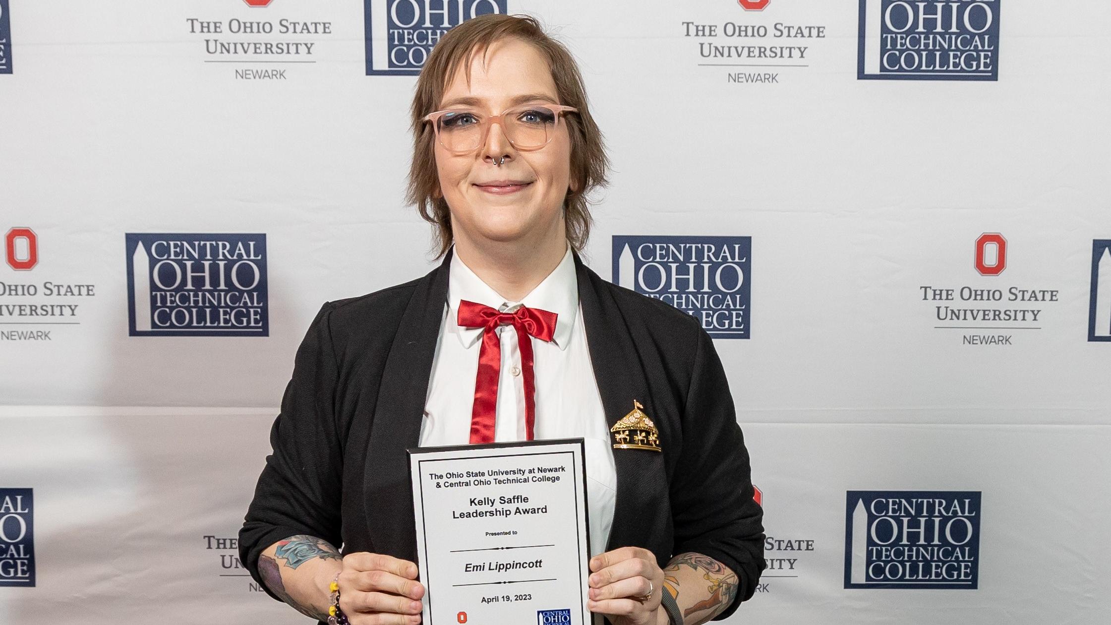 Portrait of Emi Lippincott holding her award plaque.