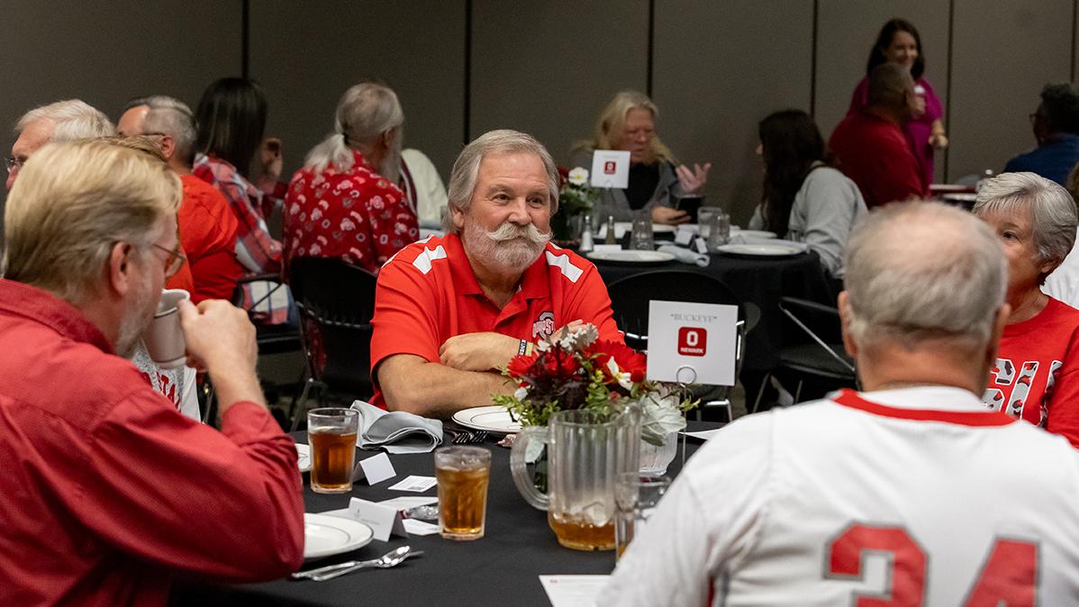 Alumni sit at a round table in conversation.