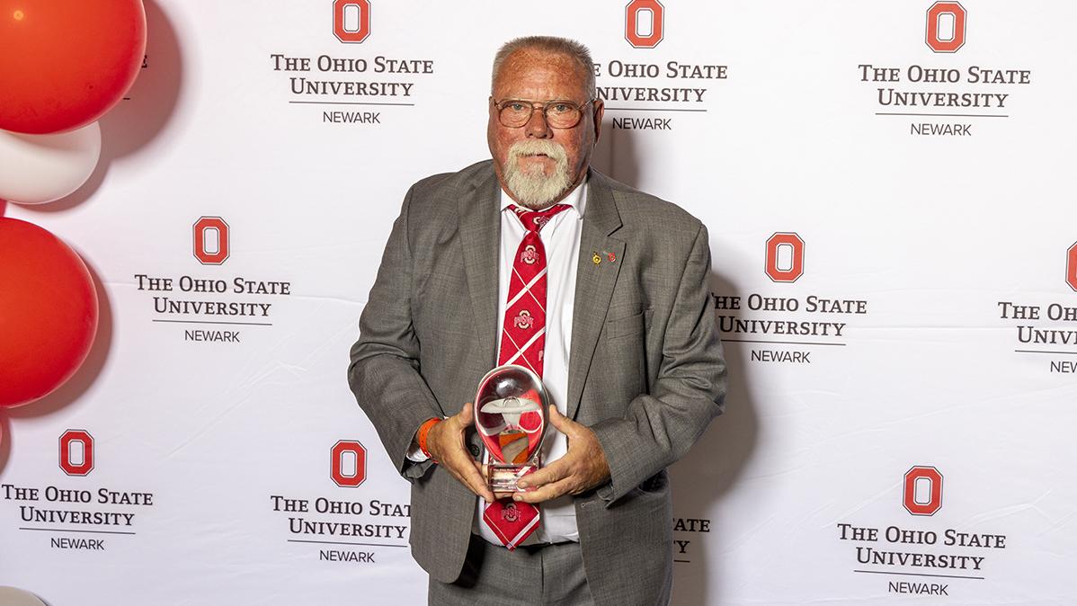 Kenneth Yeager holds his glass award for a portrait. 