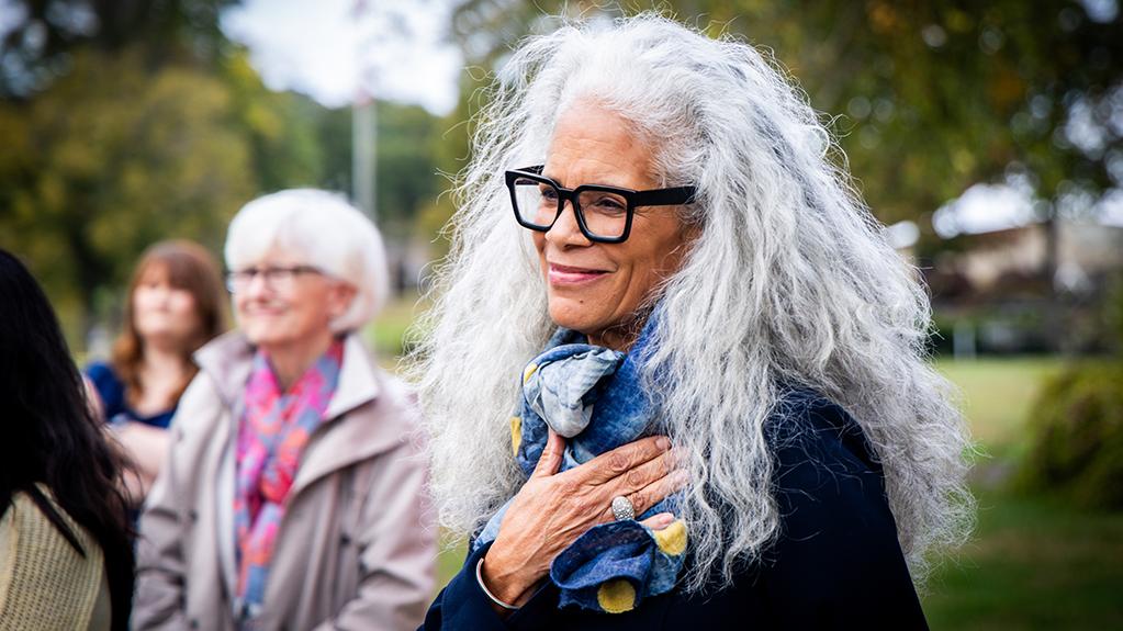 Dana King smiles and holds her hand to her chest during the unveiling of a life-size bronze sculpture she made of Civil Rights activist Ella Baker.