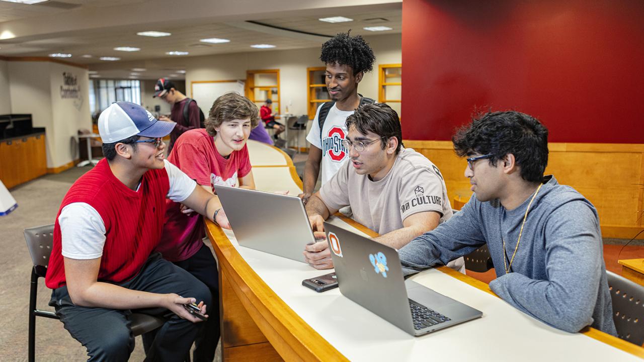 A group of students sits around a table in the Warner Center student center.