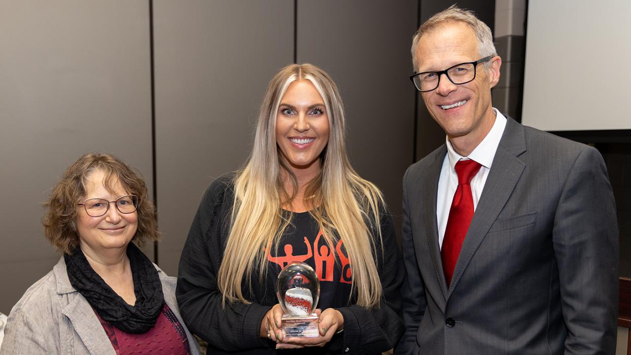 Distinguished Alumni Award recipient Olivia Biggs stands between Dean William MacDonald and Professor Elizabeth Weiser.