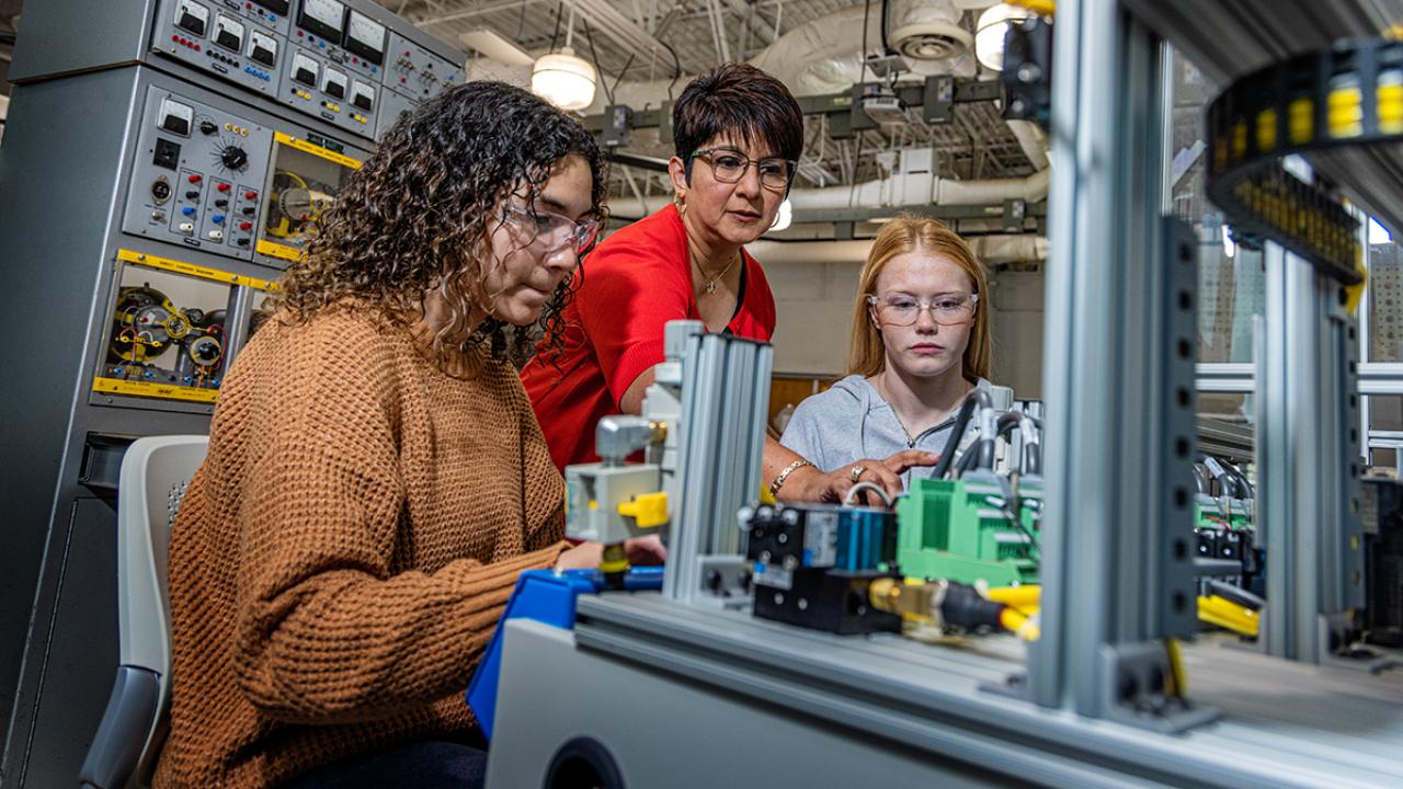 Engineering technology faculty member Sandra Soto-Caban and two students use engineering equipment in the lab.