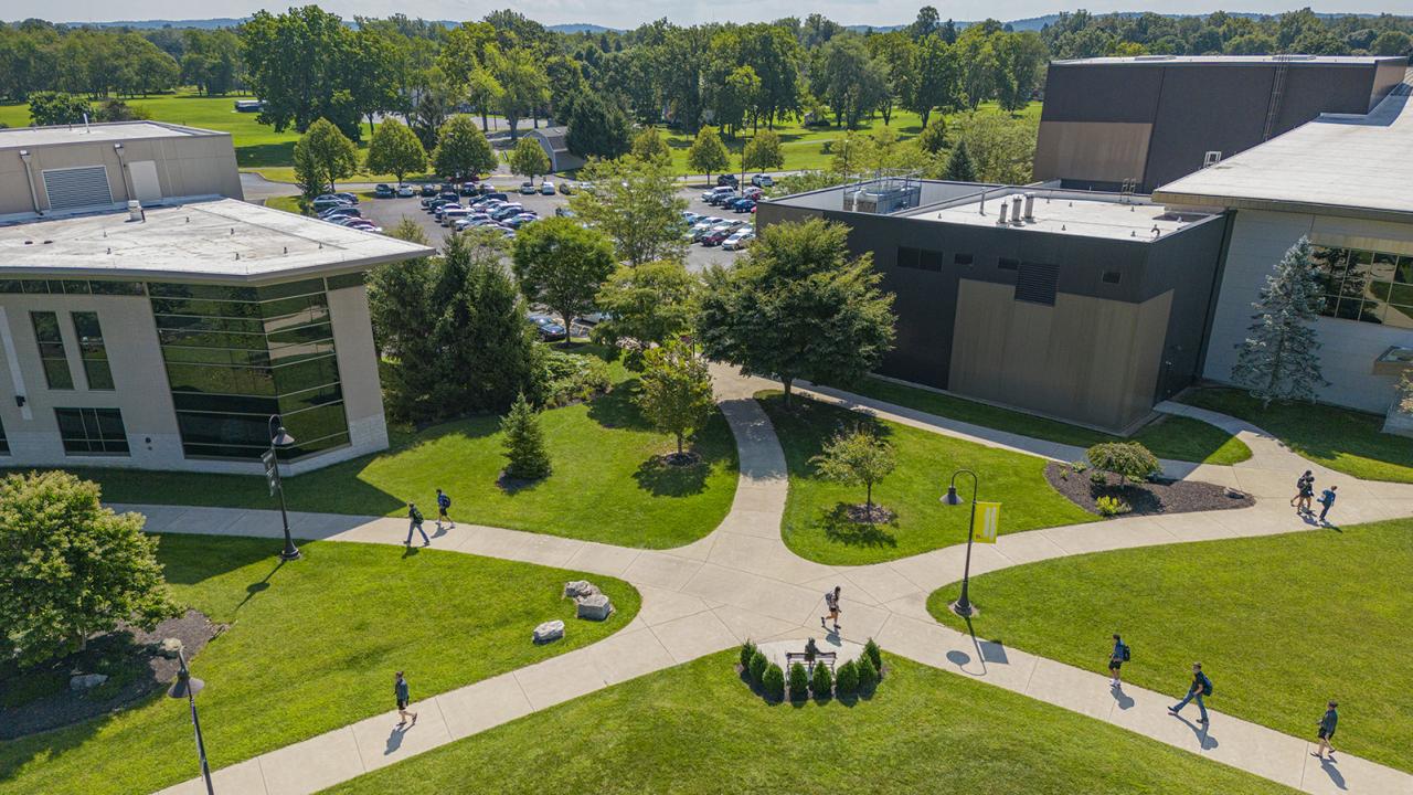 A view from above campus of students walking on sidewalks between the Warner Center and Reese Center.
