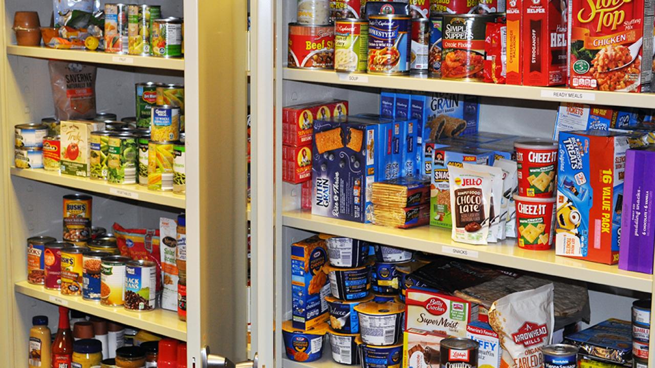 A cupboard is filled with non-perishable food items.