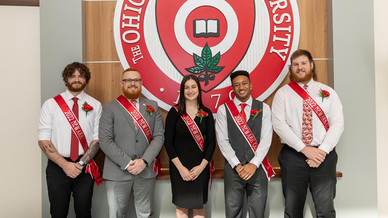 Students in Ohio State Newark's Homecoming Court stand next to the Ohio State seal at the regional campus coronation.