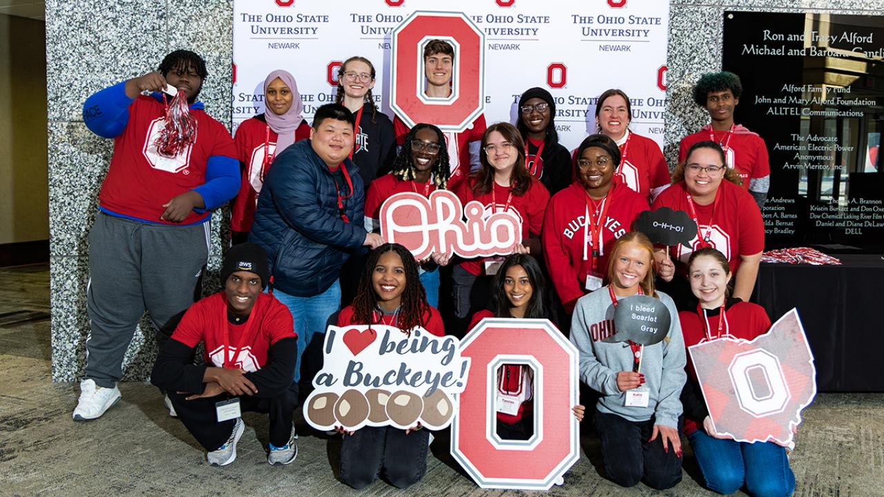 Students serving as Buckeye Guides gather with Ohio State and Block O signs.