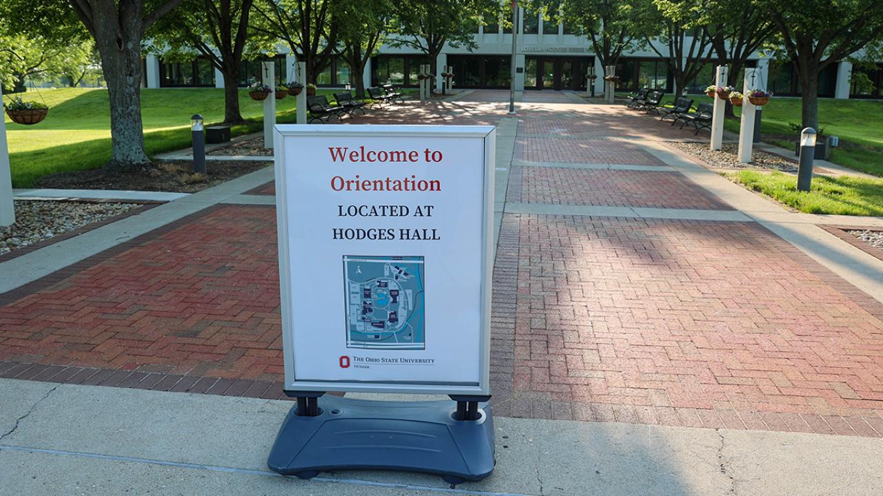A sign sitting outside says "Welcome to Orientation located at Hodges Hall" above a campus map.