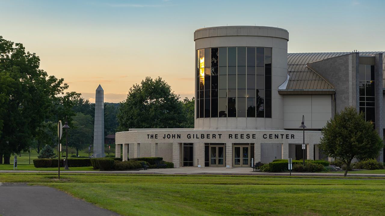 The front entrance of the Reese Center with the carillon in the background on a summer day.