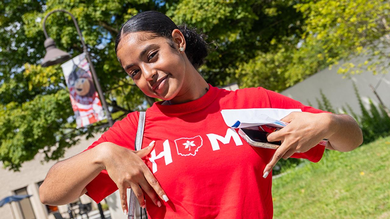 A student poses on campus following Convocation.