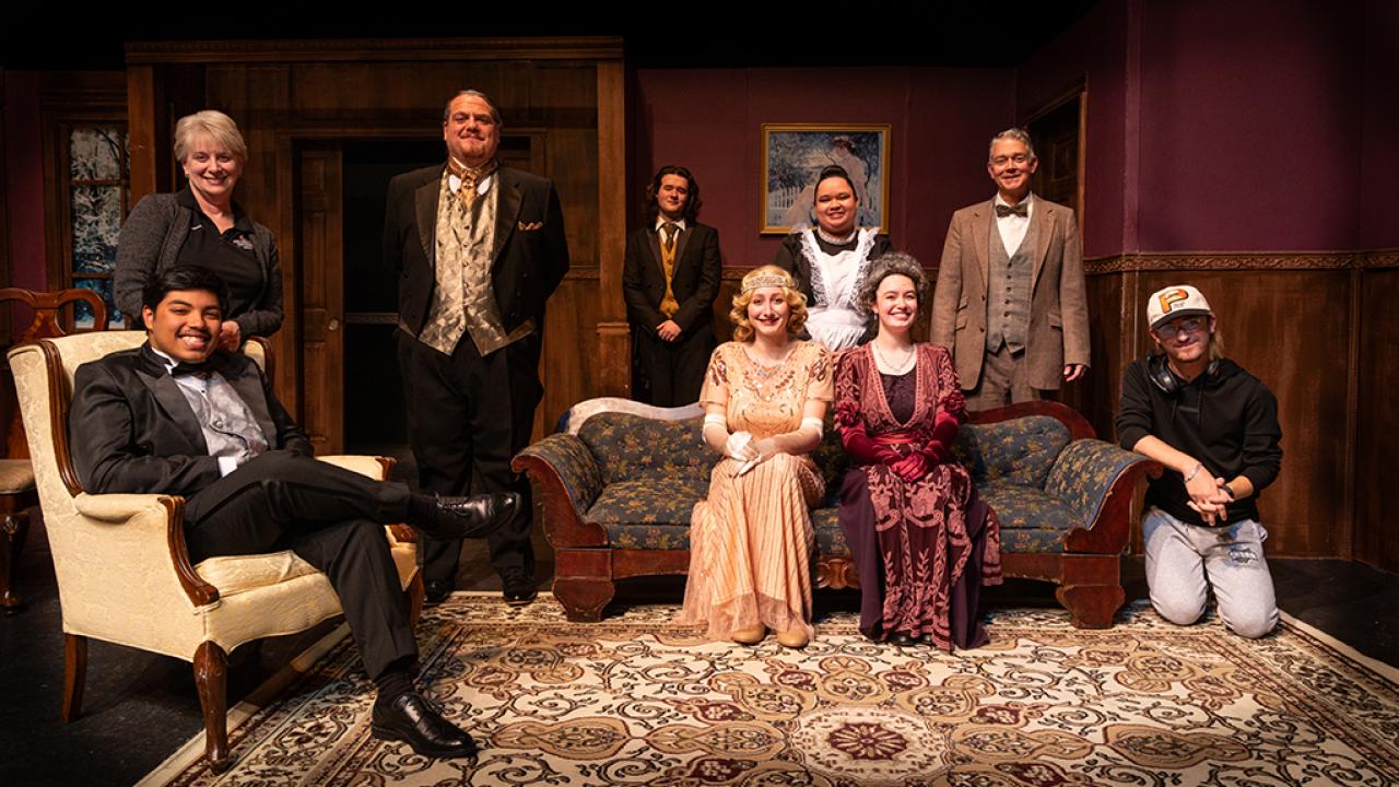 The Inspector Calls cast dressed in costume on a living room set. 