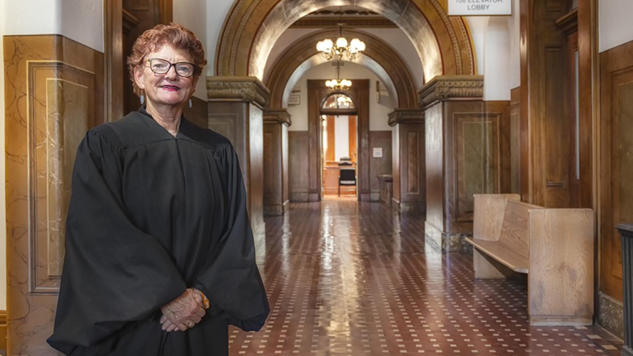 Judge LuAnn Cooperrider stands in a courthouse hallway wearing her judge's robe.