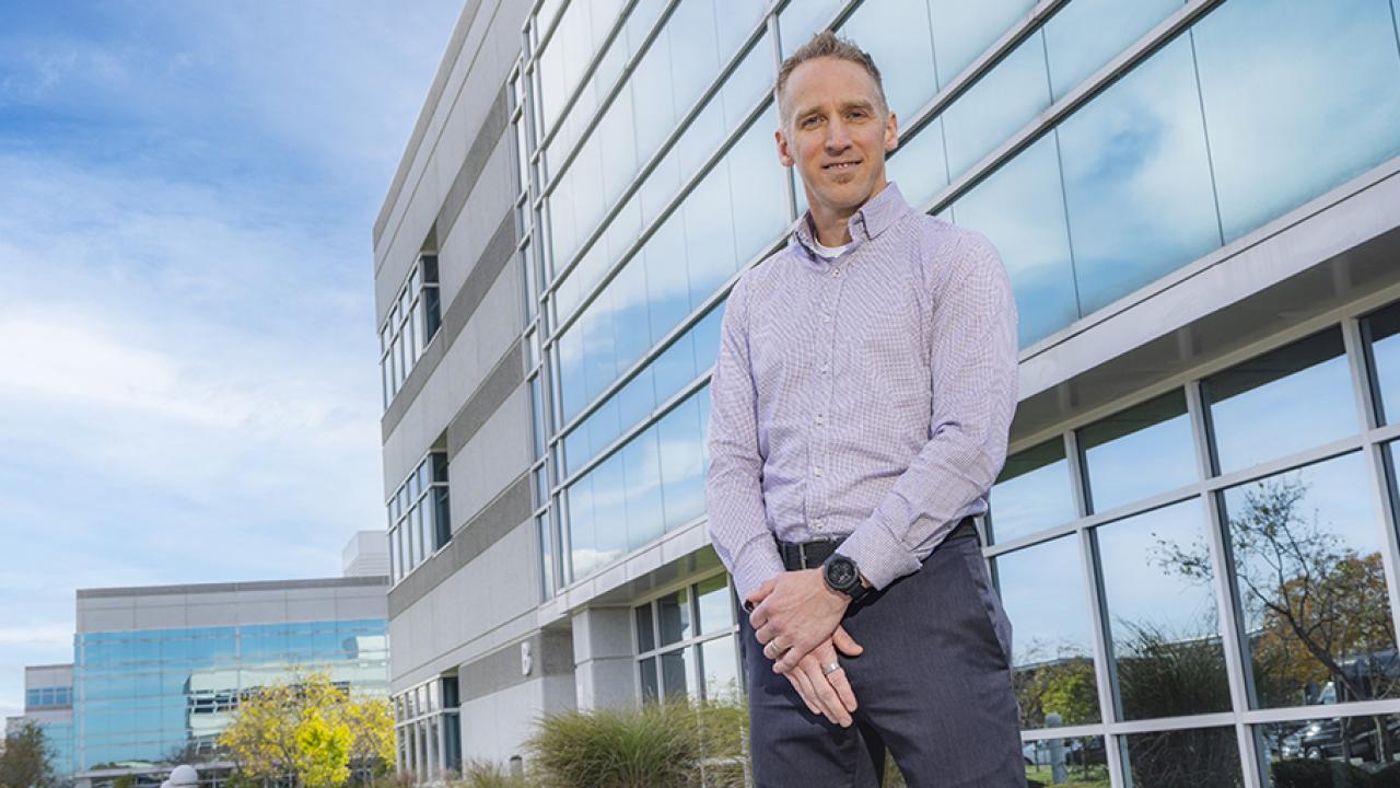Portrait of Todd Rickets standing in front of the JPMorgan Chase office building.