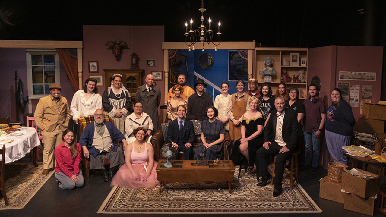 The full cast in costume and crew of the theater production "You Can't Take It With You" sit on set during a dress rehearsal of the play.